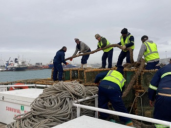 Crew members haul a hawser aboard as the ship leaves harbour.