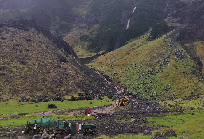 PWD working with diggers to divert the water cascading down the mountain