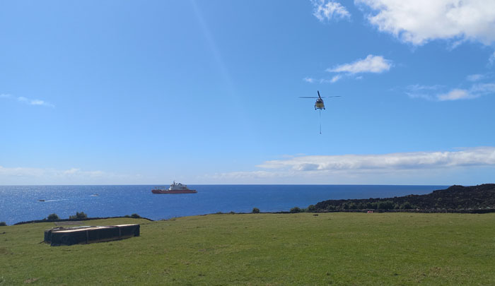 An Agulhas II helicopter above American Fence while in the background, the rafts ply between the ship and the harbour