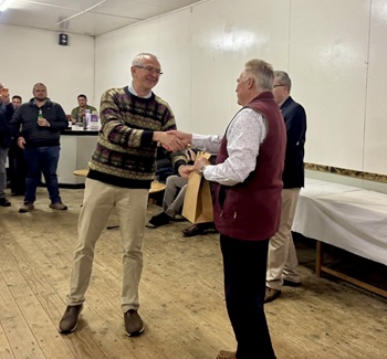 Dr Matthew Dryden being presented with a gift from the community by Dr Alex Wonner.