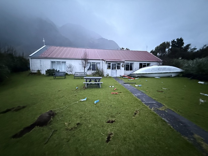 The scene in the Residency garden at daybreak, strewn with longboat debris. The longboat had been blown from the side of the road to the left in this picture, where they are all normally kept tied down.