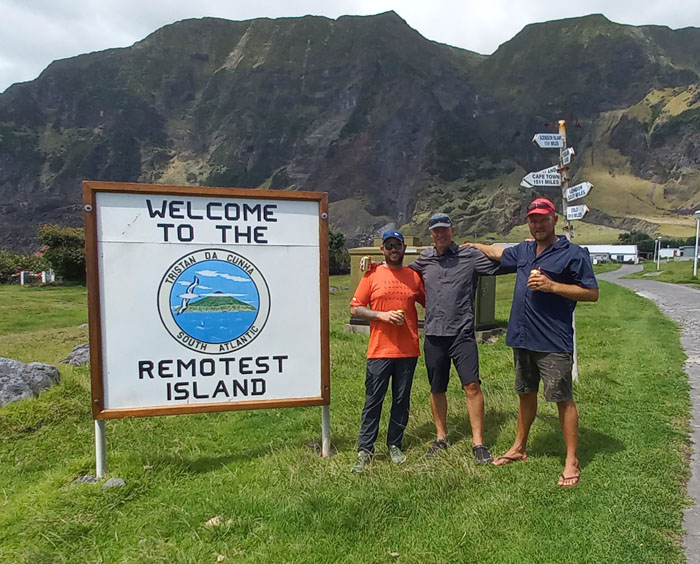 Crew of the Nyamezela next to the Remotest Island sign