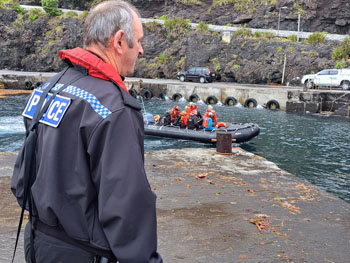 Police Adviser Bob Urquhart awaits the arrival of the ship's scout boat
